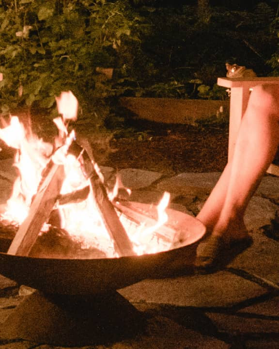 Neighbor outdoor fire pit surrounded by teak adirondack chairs