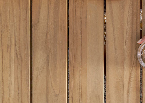 Glass of lemon water on a Neighbor teak outdoor dining table 