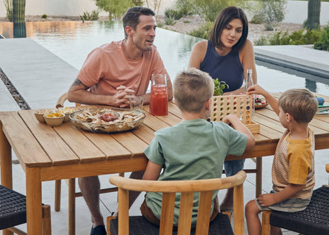 Young family eating outside on a six seater teak dining table and chairs