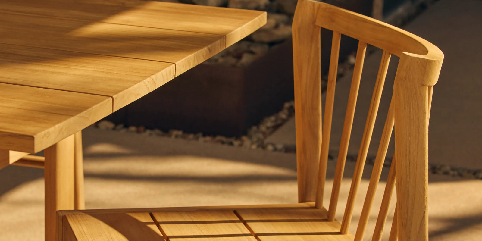 Teak outdoor dining chair next to teak dining table