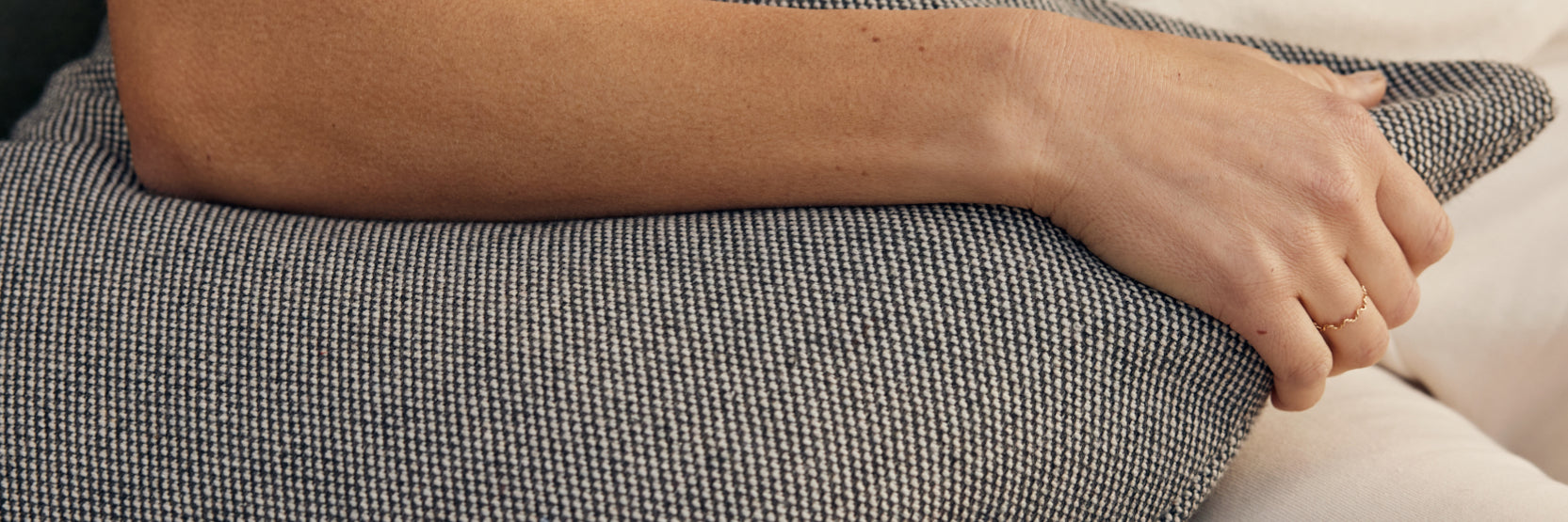 Neighbor black and white outdoor pillow being held by a person sitting on an outdoor sofa