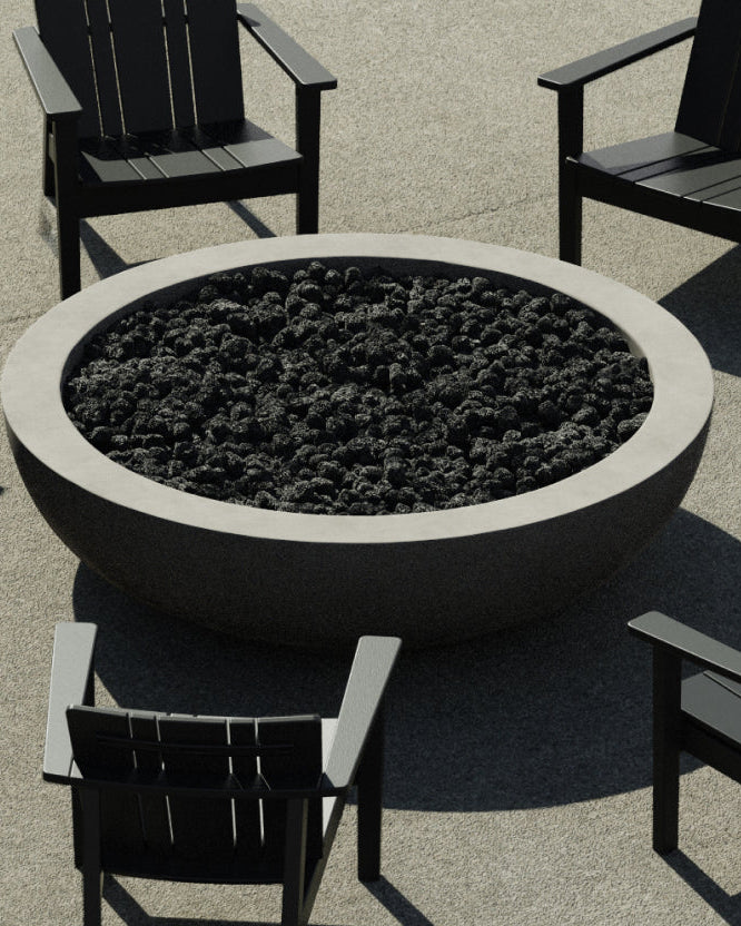 Round modern concrete fire table surrounded by black Adirondack chairs