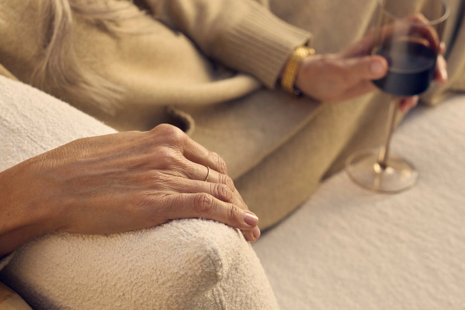 Closeup of Neighbor Dweller Chair teak arm and cream cushion detail in warm outdoor light
