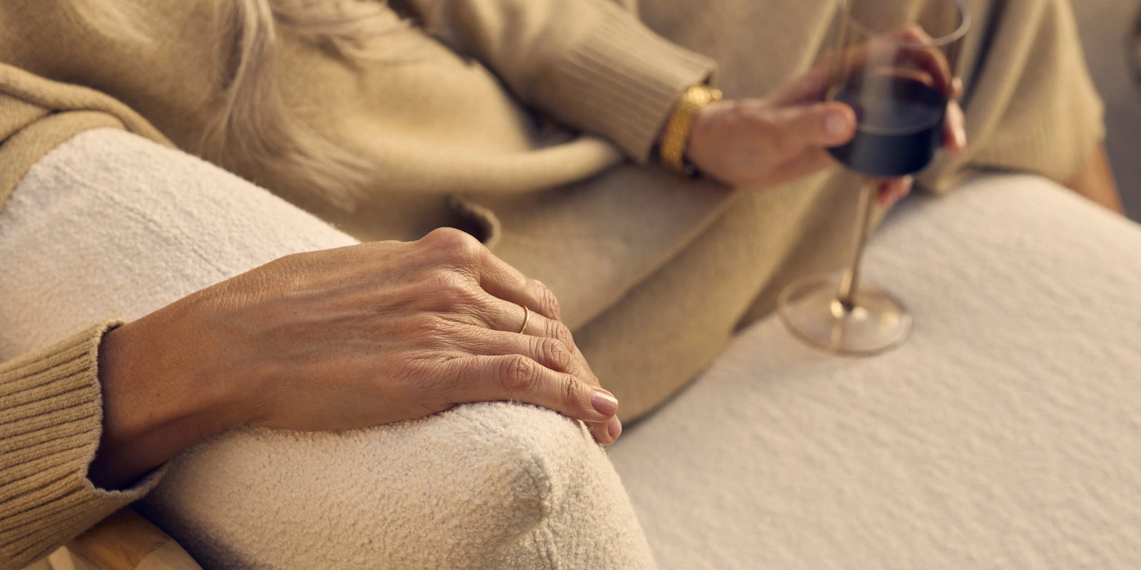 Closeup of Neighbor Dweller Chair teak arm and cream cushion detail in warm outdoor light