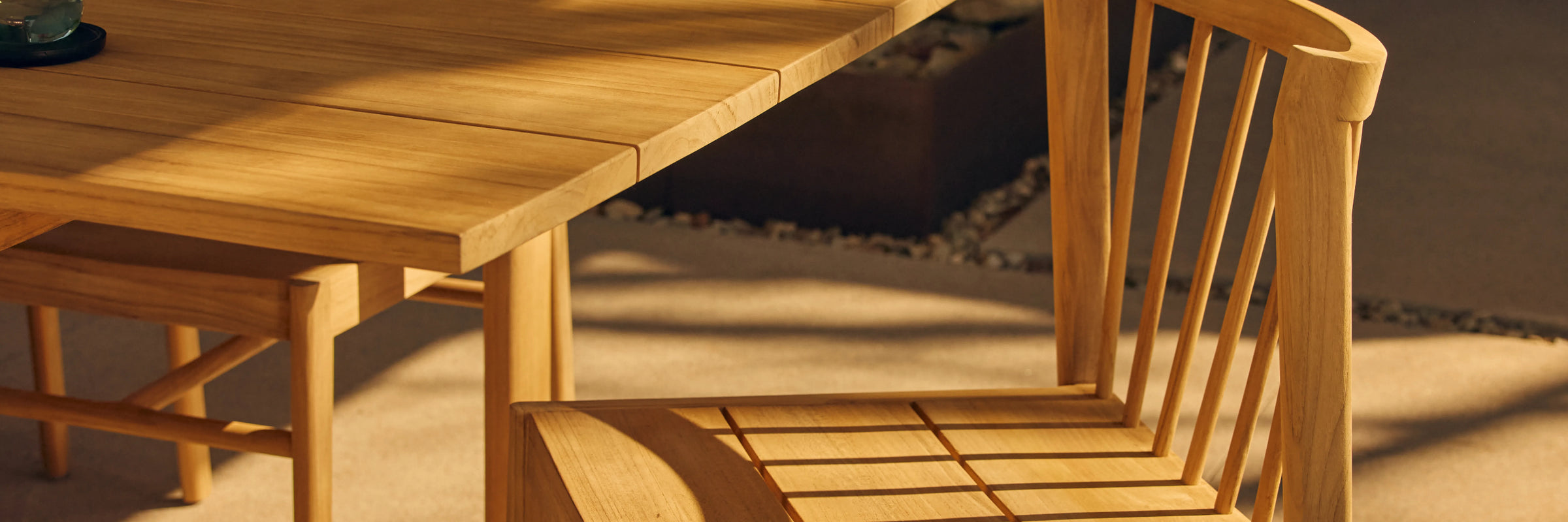 Closeup of Neighbor Felloe Dining Chair teak back spindles casting shadow in warm afternoon light