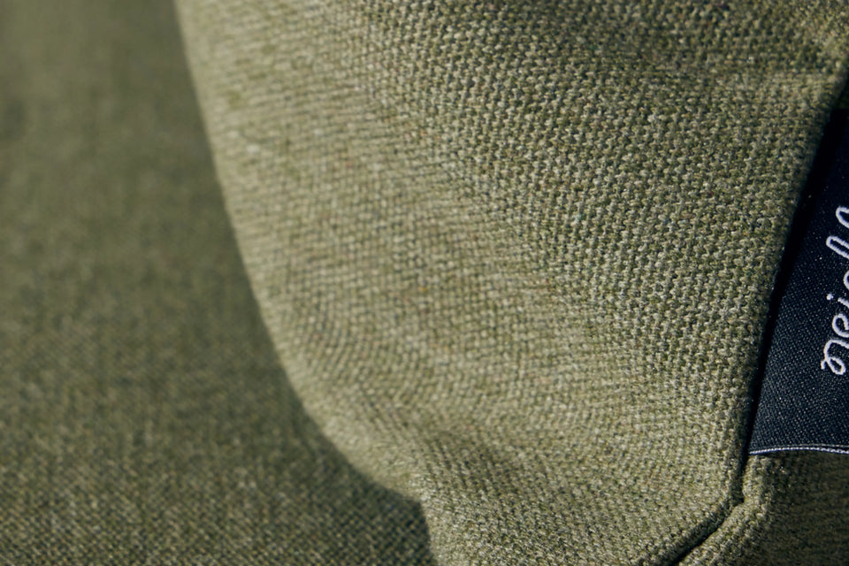 Closeup of Neighbor Haven Throw Pillow fabric texture in olive green on outdoor sofa cushion