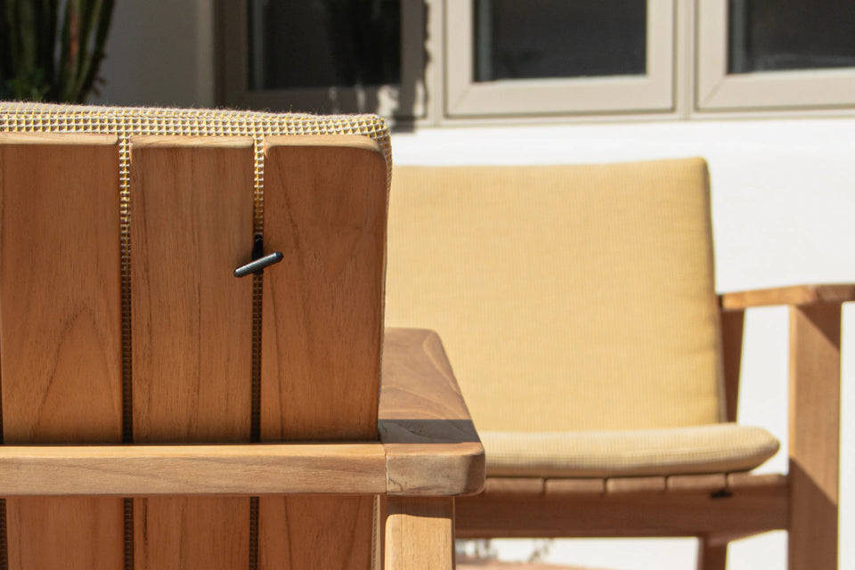 Closeup of Neighbor Low Bench Pad cream cushion on teak bench in afternoon sun on terracotta tile patio