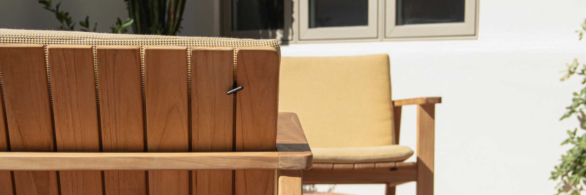 Closeup of Neighbor Low Chair Pad cream fabric on teak chair seat in outdoor afternoon light