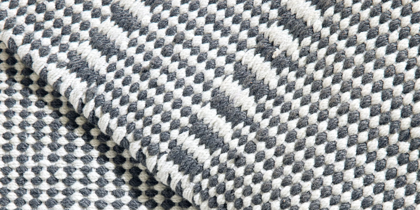 Closeup of Neighbor Field Outdoor Rug woven texture and pattern detail on patio