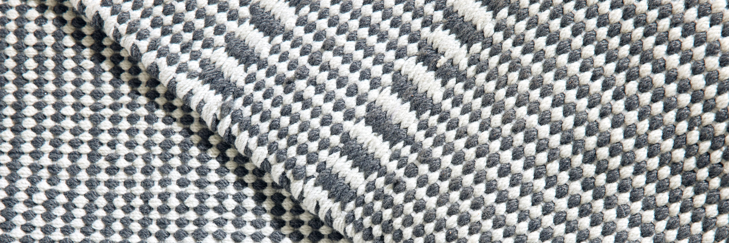 Closeup of Neighbor Field Outdoor Rug woven texture and pattern detail on patio