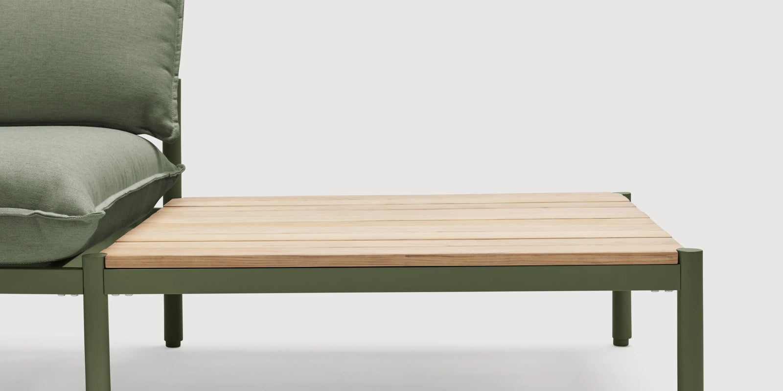 Woman on Neighbor Terra Sofa with End Table in cream fabric and teak frame on a covered wood-slat patio