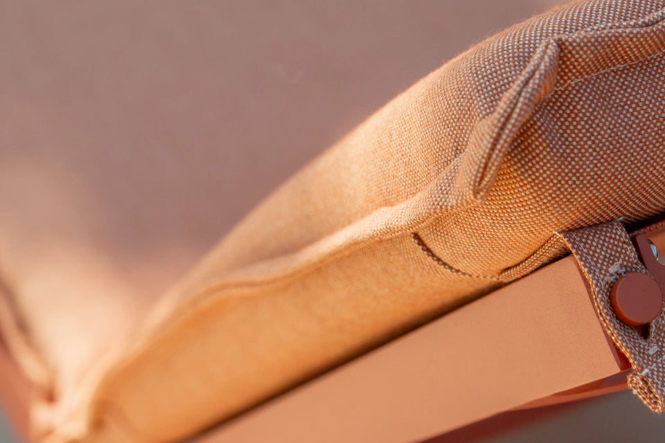 Closeup of Neighbor Terra Sun Lounger cream cushion and teak frame detail in outdoor light