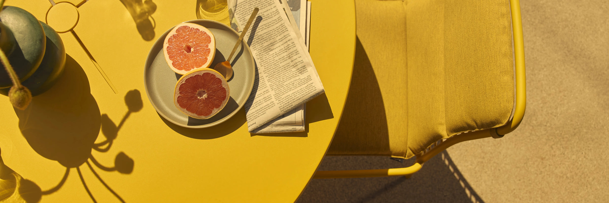 Closeup of Neighbor XY Dining Set yellow aluminum chairs and table top in outdoor evening light