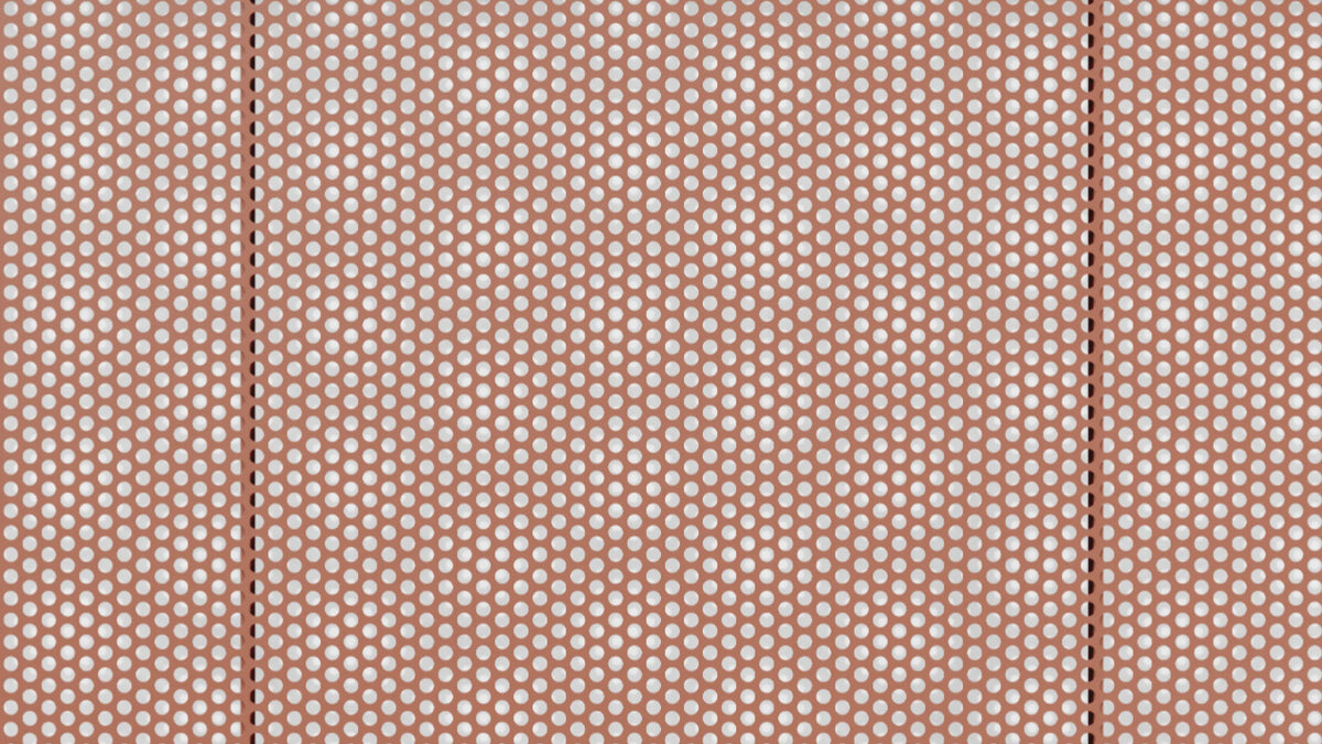 Perforated metal surface detail — macro overhead of Perf tabletop in terracotta showing uniform dot pattern and panel seam