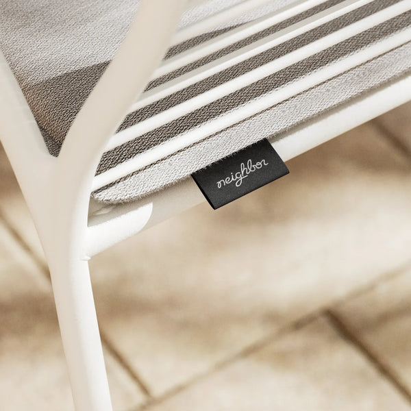 Neighbor label detail — closeup of XY Chair striped cushion on slatted seat with Neighbor label visible