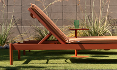 Aluminum sun lounger in terracotta finish with matching terracotta cushion and integrated side table on a lawn patio — Aluminum Outdoor Furniture collection