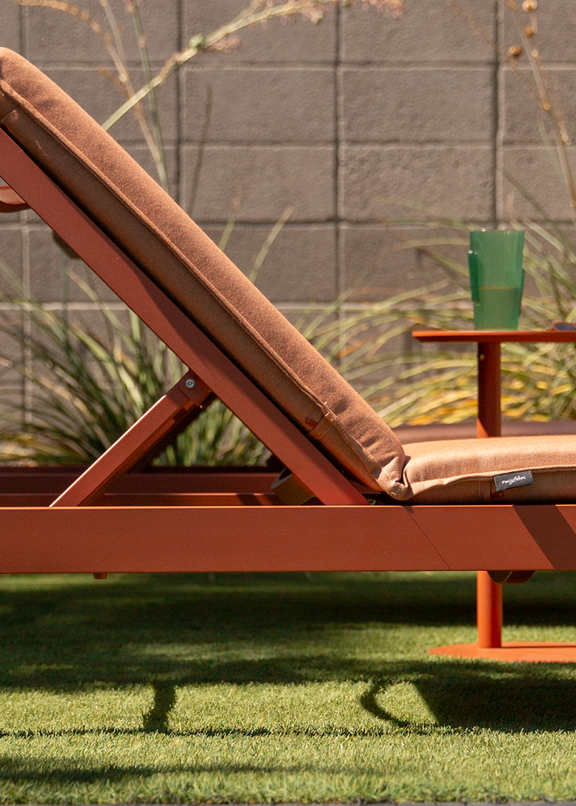 Aluminum sun lounger in terracotta finish with matching terracotta cushion and integrated side table on a lawn patio — Aluminum Outdoor Furniture collection