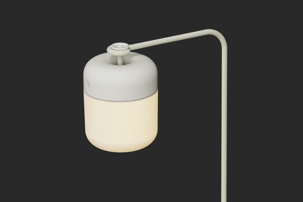 Neighbor Acorn Lantern Stand in putty finish with warm glow, displayed on dark surface
