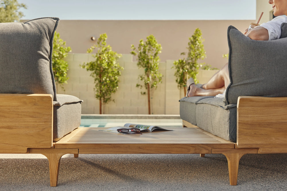 Neighbor Bluff Sectional with in-line table separating two seating areas, modern courtyard setting