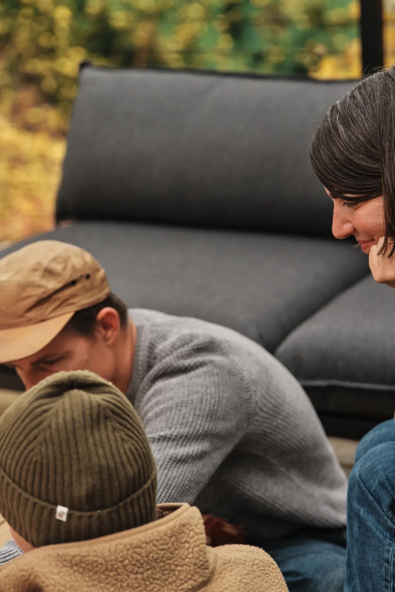 Amanda Jones leans in close with her family gathered around the dark Terra outdoor sectional on their deck