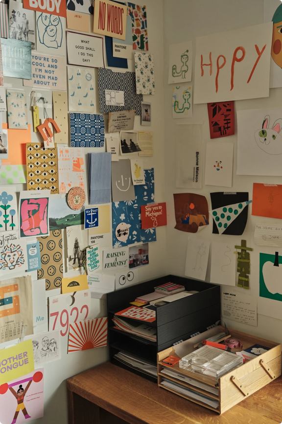 Colorful mood board and prints pinned to the wall in Amanda Jane Jones's studio