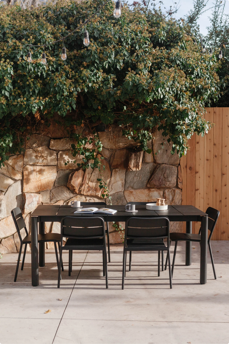The Neighbor dining table set up outdoors beneath autumn trees