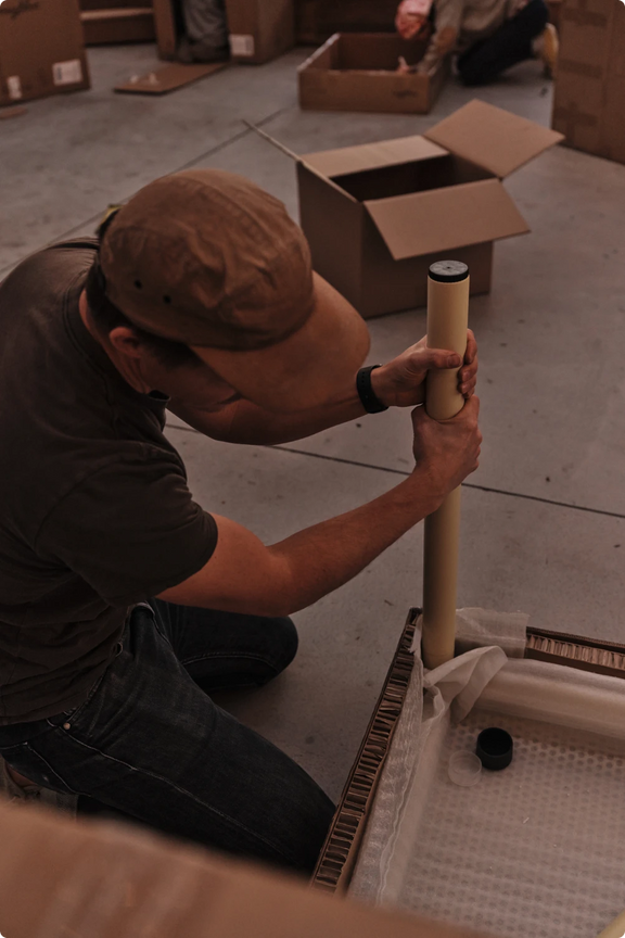Cree Jones assembling outdoor furniture with tools and cardboard packaging nearby