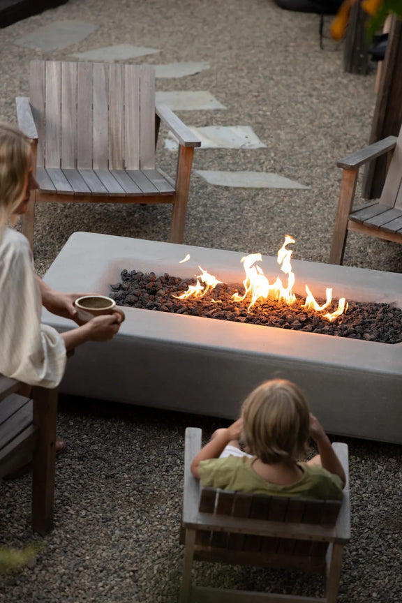 Taylr Anne Castro and her son sit near the lit fire table, seen from behind