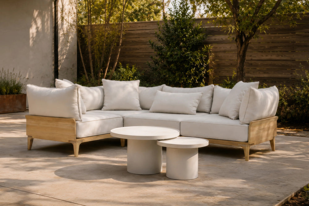 Neighbor Ped Side Table Short in Bone nested with the Ped Coffee Table before a teak sectional on a concrete patio