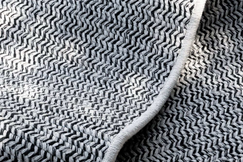 Neighbor Braid Rug in Pepper, close-up of chevron pattern in charcoal grey and white with rolled edge detail