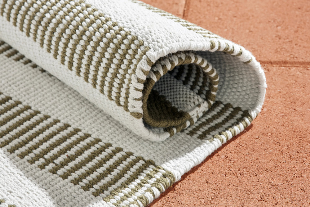 Neighbor Dune Rug in Basil, detail view of woven cream and sage striped pattern with rolled edge showing texture