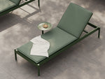 Neighbor Terra Sun Lounger in Charcoal with Putty cushions, modern reclining chaise on concrete patio with drink table