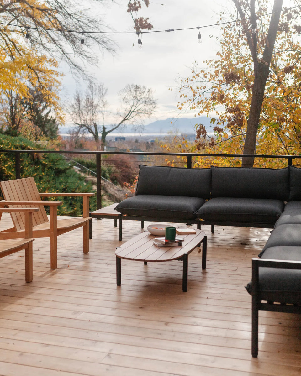 Terra Sectional, Terra Coffee Table and Low Chairs on a wooden deck surrounded by foliage. 