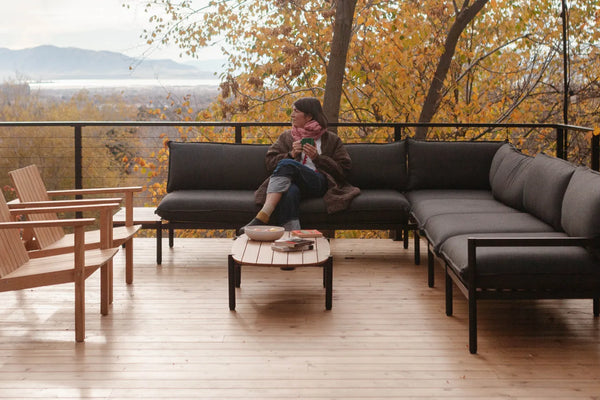 Amanda Jane Jones sitting on a Neighbor Terra Sectional outside on a wooden deck. 