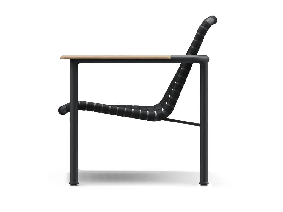 Studio side profile of a Neighbor Up-Down Chair on a clean white background, showing the curved charcoal woven-strap seat-and-back sling, natural-wood armrest, and black powder-coated tubular steel frame.
