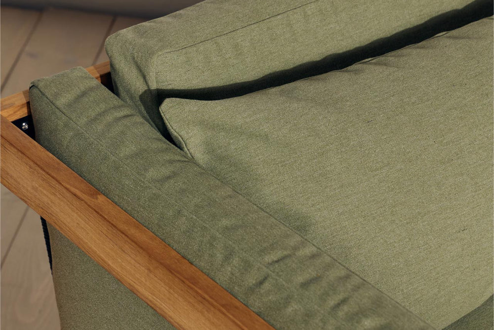 Overhead close-up of sage green Neighbor outdoor sofa cushion fitting into a teak frame corner