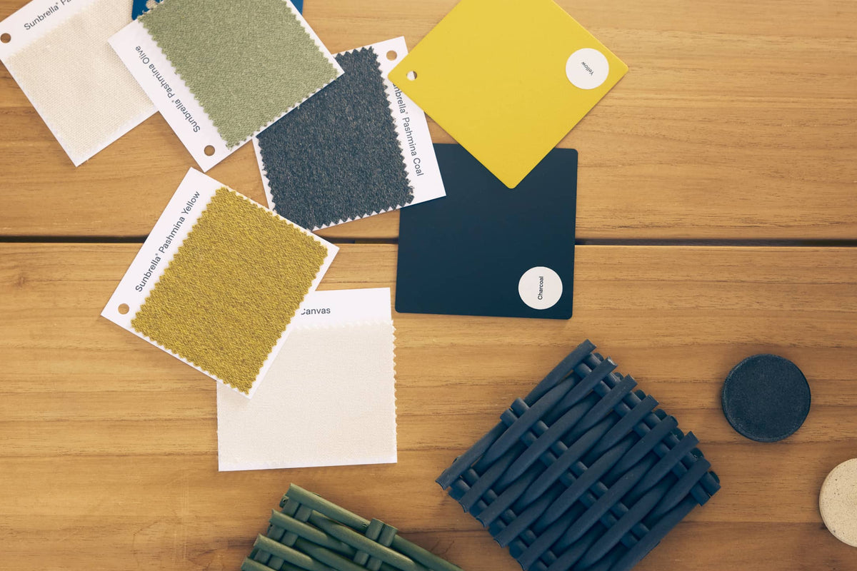 Flat lay of Neighbor material swatches on a teak surface including fabric, polywood, and woven cord samples